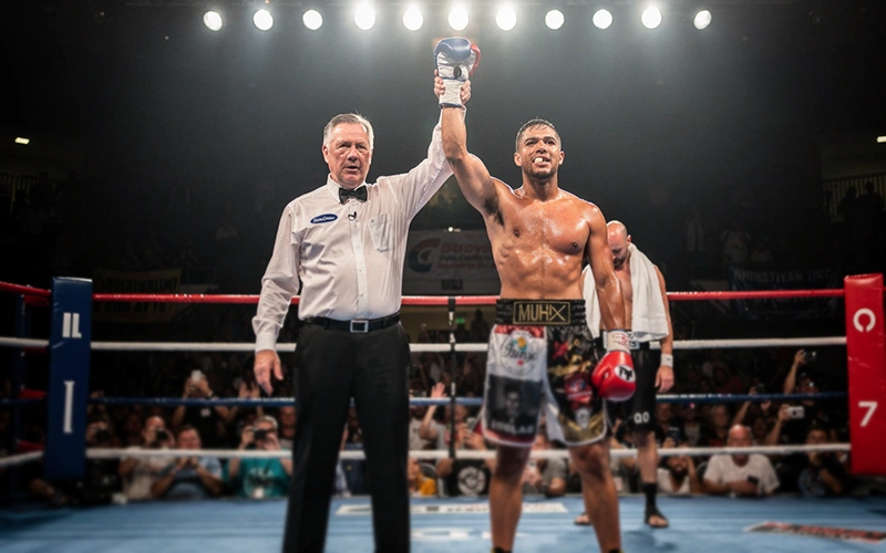 Ringrichter hebt die Hand des Siegers nach Boxkampf